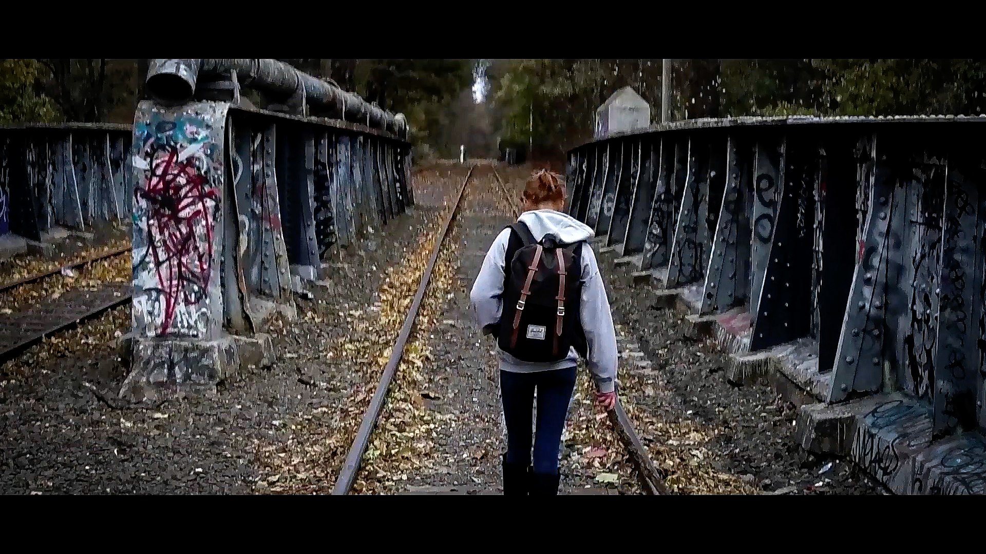 Anne Hatchet — train bridge, backpack figure walking