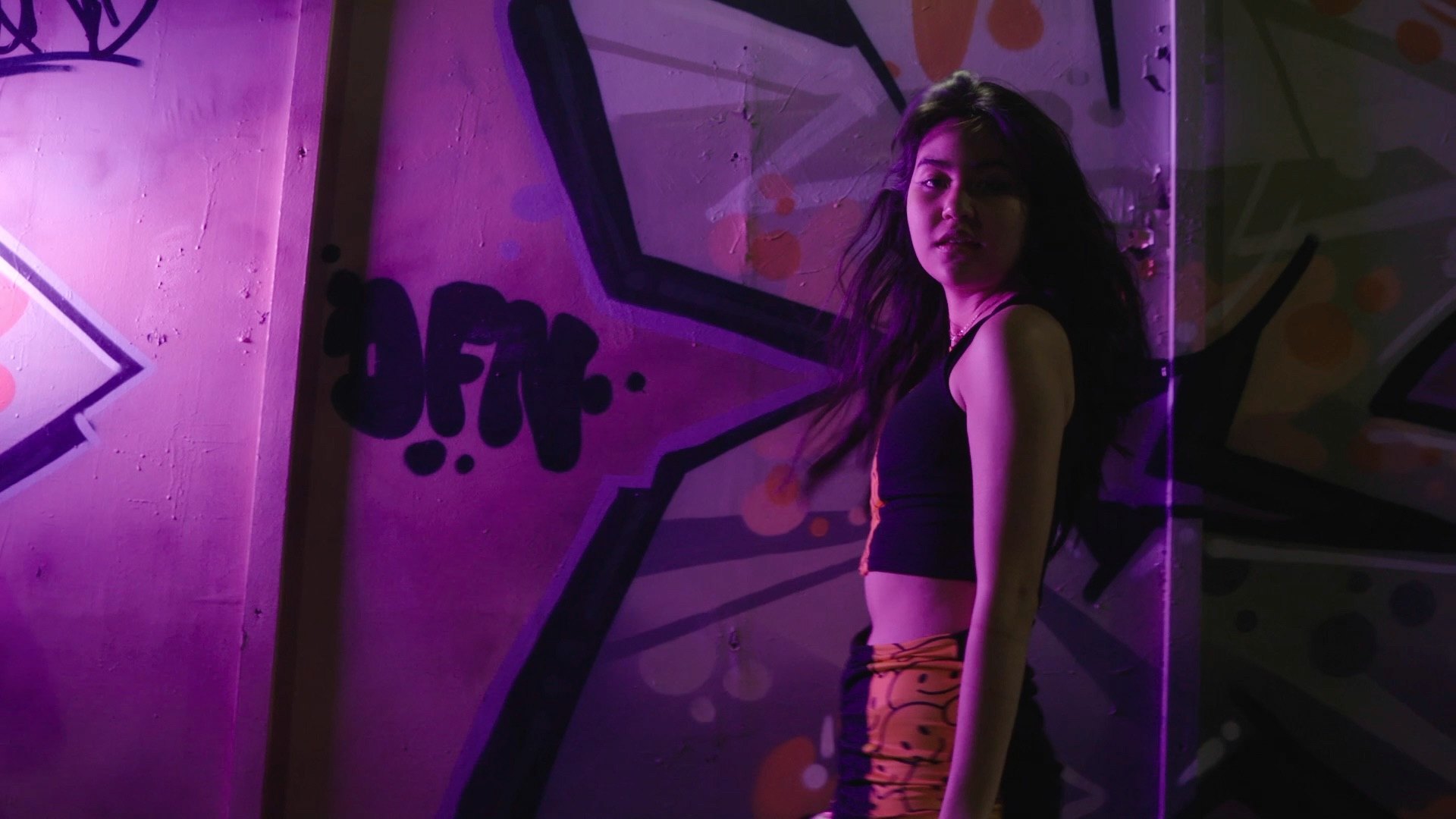 QWRKI — figure against neon graffiti wall